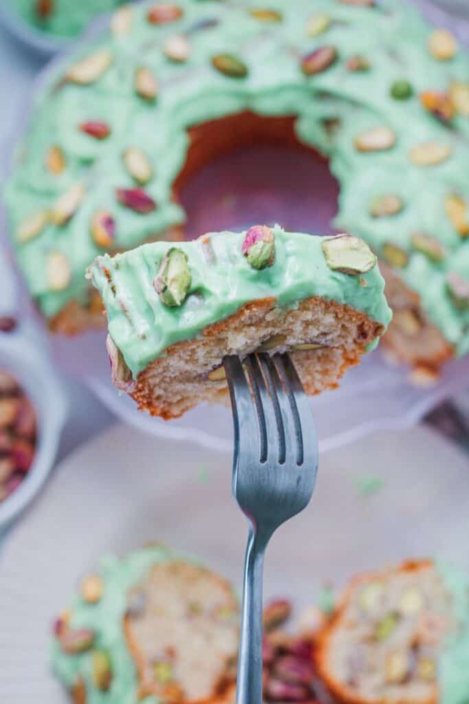 Small piece of pistachio bundt cake with fork through it.
