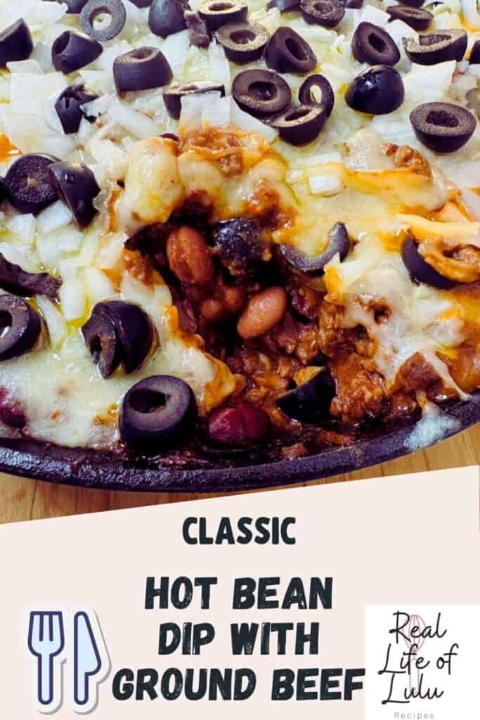 A baked casserole dish filled with hot bean dip topped with melted cheese, sliced black olives, and diced onions, with a serving scooped out to show the ground beef and beans inside. Text reads: Classic Hot Bean Dip with Ground Beef.