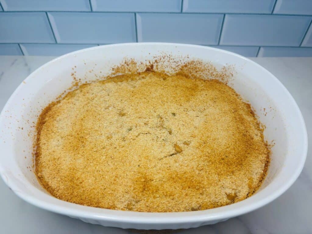 A round baking dish containing a golden-brown casserole topped with breadcrumbs.